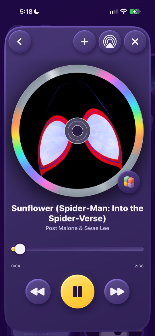 The song card: the album art spinning as a disc, a big yellow pause button, previous and next